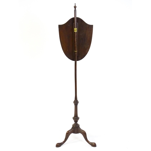 1829 - An early 20thC  pole screen with a shield shape embroidery raised on a turned pole and three cabriol... 