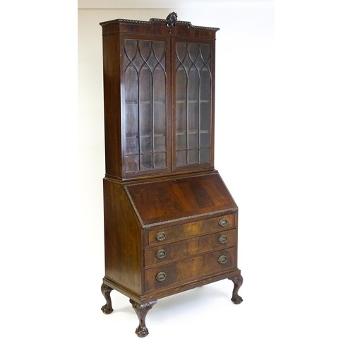 1832 - An early 20thC mahogany bureau bookcase with a carved cornice above two astragal glazed doors and a ... 