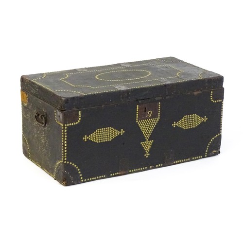 1865 - A 19thC trunk with a leather exterior and brass stud detailing, the chest flanked by wrought iron ca... 