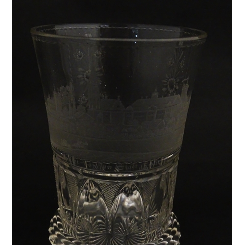 279 - A Continental drinking glass with cut decoration and etched scene depicting a Continental town lands... 