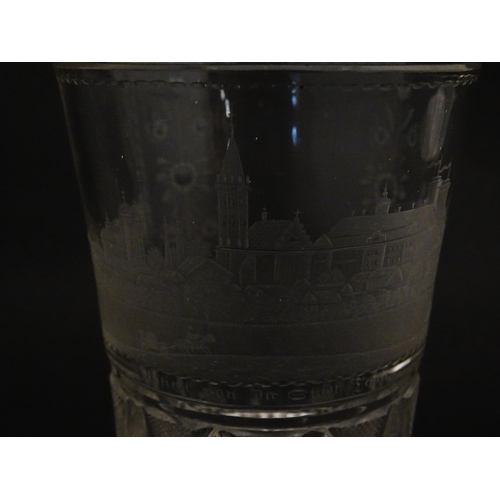 279 - A Continental drinking glass with cut decoration and etched scene depicting a Continental town lands... 