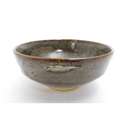40A - An Oriental bowl with mottled glaze. Impressed Character marks under. Approx. 2 3/4
