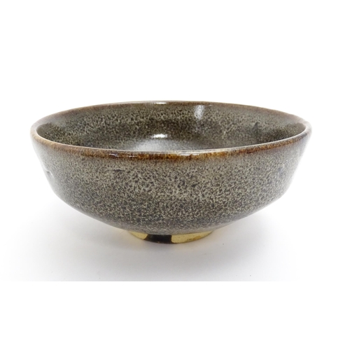 40A - An Oriental bowl with mottled glaze. Impressed Character marks under. Approx. 2 3/4