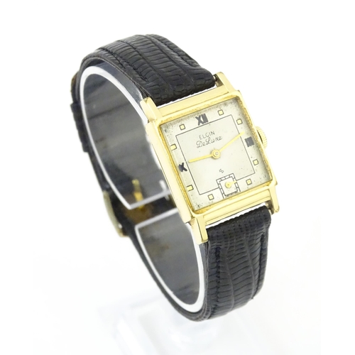 1037 - A vintage Elgin Deluxe 10k gold filled gentlemans wristwatch with squared dial and subsidiary second... 