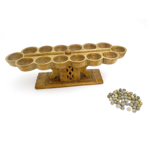 1197 - Ethnographic / Native / Tribal: An African Ashanti / Asante mancala games board raised on a carved a... 