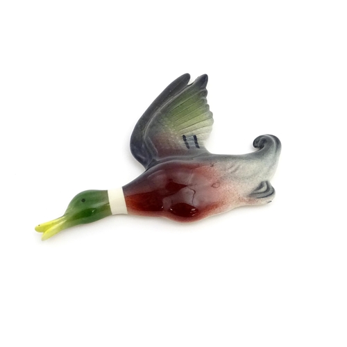 181A - A ceramic wall plaque modelled as a mallard duck in flight painted by Peter Scott. Marked under. App... 