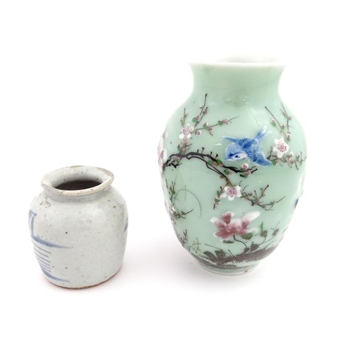 6 - A Chinese celadon vase with hand painted bird and blossom detail. Together with a Chinese blue and w... 