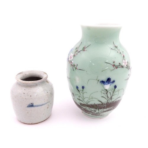 6 - A Chinese celadon vase with hand painted bird and blossom detail. Together with a Chinese blue and w... 