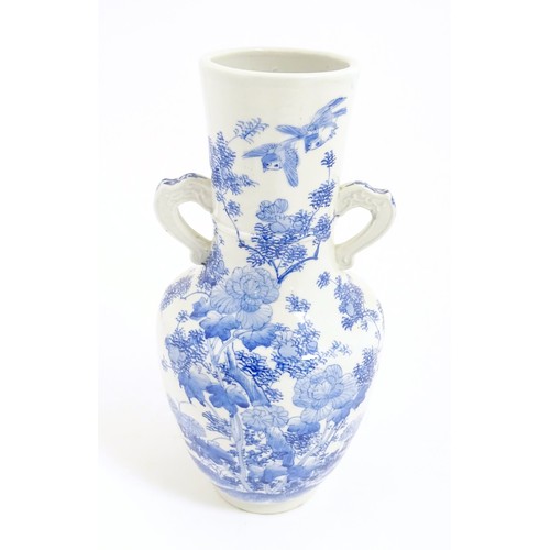 8 - A Japanese blue and white twin handled vase with hand painted decoration depicting birds, flowers an... 