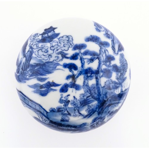 29 - A Chinese blue and white ink box of circular form decorated with figures in a landscape scene with a... 