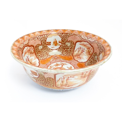 4 - An Oriental bowl decorated in the Kutani palette with central dragon motif, the sides with landscape... 