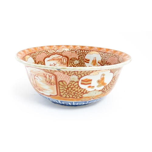 4 - An Oriental bowl decorated in the Kutani palette with central dragon motif, the sides with landscape... 