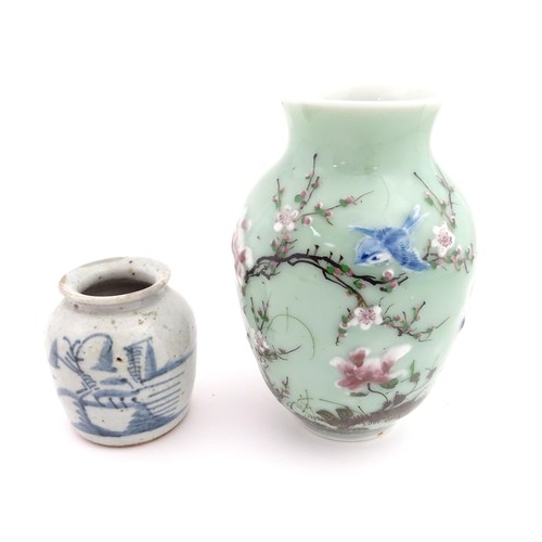 7 - A Chinese celadon vase with hand painted bird and blossom detail. Together with a Chinese blue and w... 