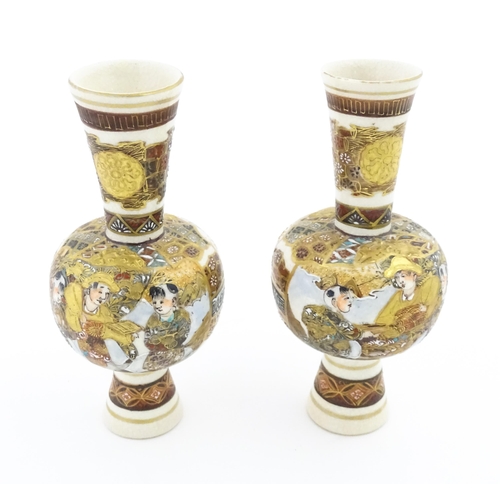 31 - A pair of small Japanese satsuma vases with elongated necks decorated with figures and banded detail... 