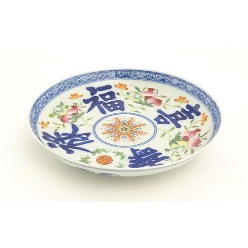 34 - A Chinese plate decorated with pomegranates, flowers and character marks, with bat decoration to rev... 