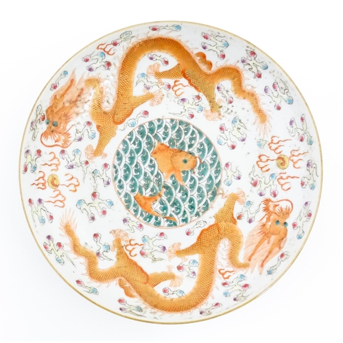 36 - A Chinese dish decorated with central koi carp fish bordered by dragons, flaming pearls, and stylise... 