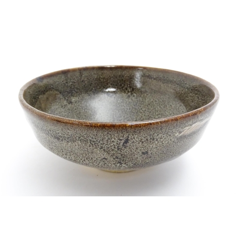 39 - An Oriental bowl with mottled glaze. Impressed Character marks under. Approx. 2 3/4