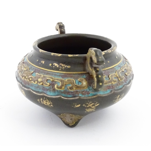 42 - A small Chinese censer with twin handles with banded decoration in relief depicting stylised dragons... 
