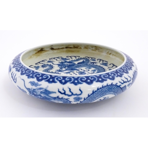 45 - A Chinese blue and white dish decorated with dragons amidst clouds. Character marks under. Approx. 1... 