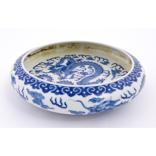 45 - A Chinese blue and white dish decorated with dragons amidst clouds. Character marks under. Approx. 1... 