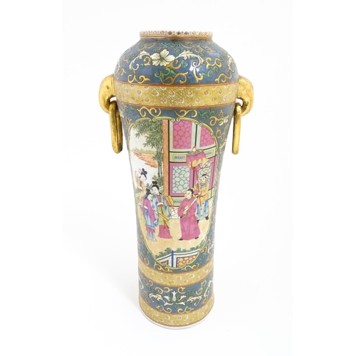 51 - A Chinese vase with twin elephant mask and ring handles decorated with figures with fans on a garden... 