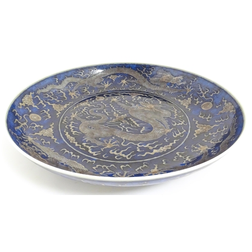 54 - A Chinese charger with blue ground decorated with dragons, flaming pearls and stylised clouds. Chara... 