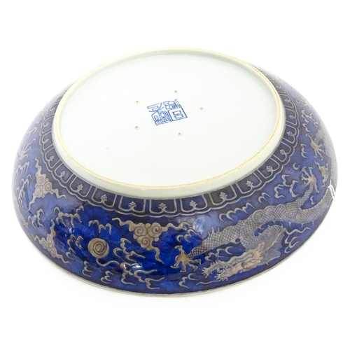 54 - A Chinese charger with blue ground decorated with dragons, flaming pearls and stylised clouds. Chara... 