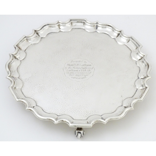 451 - A silver salver with hammered decoration and raised on three feet, hallmarked London 1903, maker Tho... 