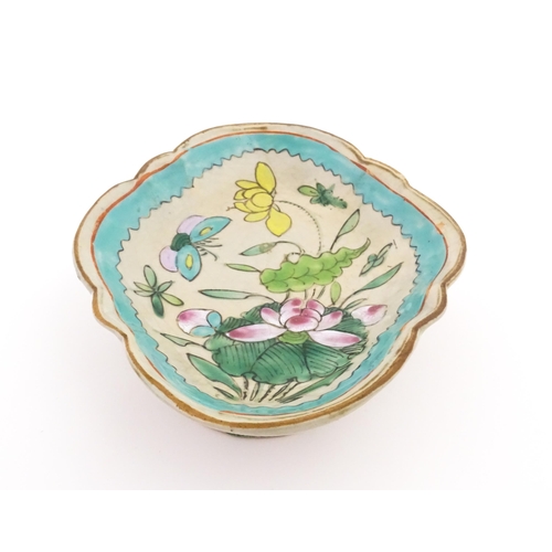11 - A Chinese footed dish of shaped form decorated with flowers, foliage and butterflies. Approx. 2