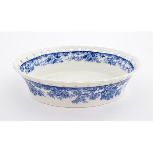 115 - A Mintons blue and white chestnut bowl with banded floral decoration and pierced rim. Marked under. ... 