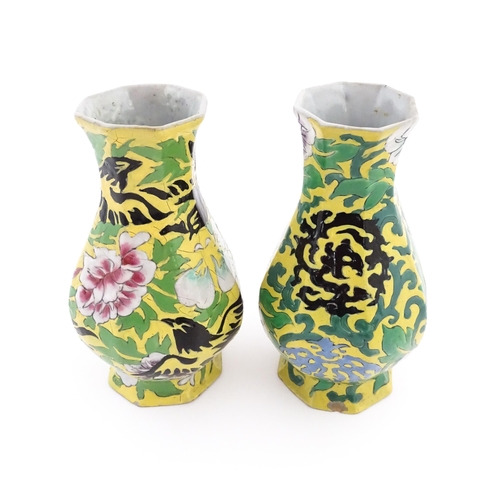 12 - Two Chinese vases of octagonal form with a yellow ground decorated with flowers and foliage. Approx.... 