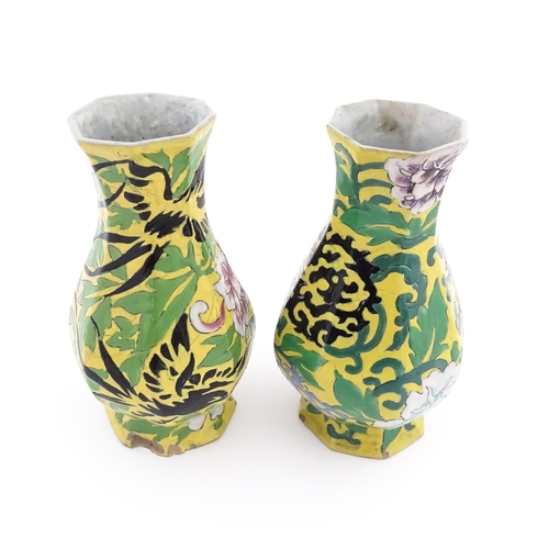 12 - Two Chinese vases of octagonal form with a yellow ground decorated with flowers and foliage. Approx.... 