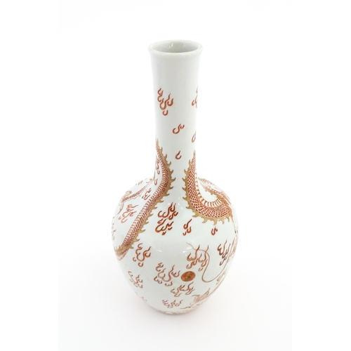 13 - A Chinese bottle vase decorated with a dragon, flaming pearl, stylised clouds and waves. Character m... 