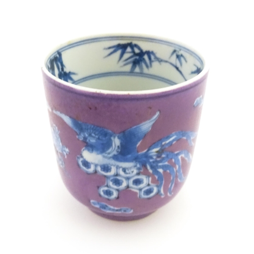 14 - A Chinese cup with a purple ground decorated with birds, foliage and stylised clouds. Character mark... 