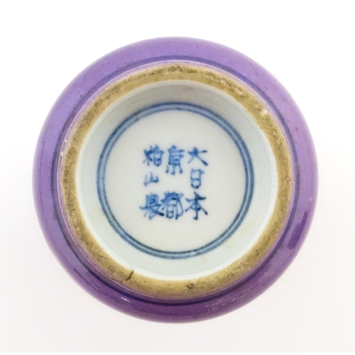 14 - A Chinese cup with a purple ground decorated with birds, foliage and stylised clouds. Character mark... 