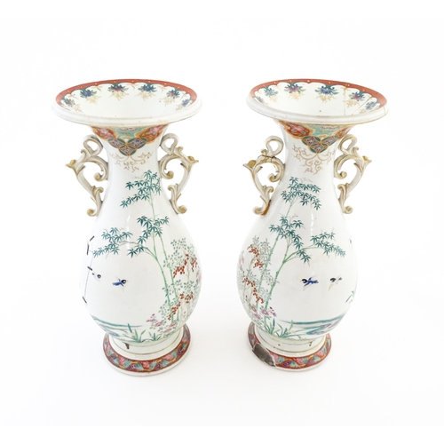 49 - A pair of Japanese vases with flared rim and twin handles, decorated with a vignette depicting figur... 