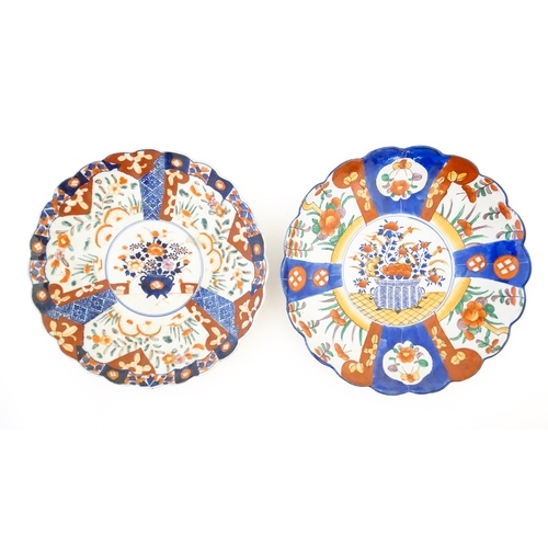 55 - Two Japanese chargers with scalloped edges decorated in the Imari palette depicting flowers and foli... 