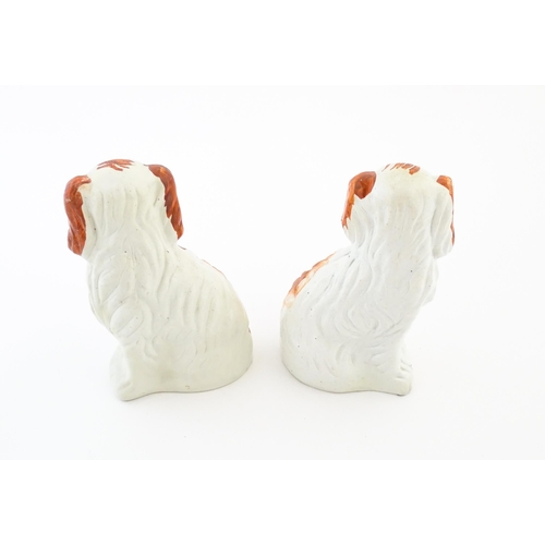 57 - A pair of Victorian Staffordshire pottery dogs, each holding a basket of flowers. Approx. 8