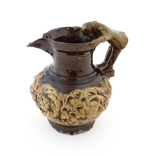 58 - A 19th century Castle Hedingham treacle glazed jug by Edward Bingham with banded relief foliate and ... 