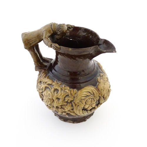 58 - A 19th century Castle Hedingham treacle glazed jug by Edward Bingham with banded relief foliate and ... 