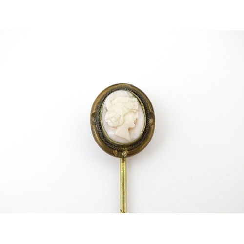 834 - A late 19thC / early 20thC gilt metal stick pin surmounted by a cameo. Approx 3