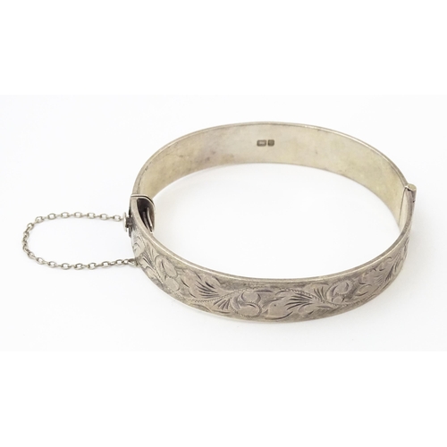 866 - A silver bracelet of bangle form with engraved acanthus scroll decoration hallmarked Birmingham 1976... 