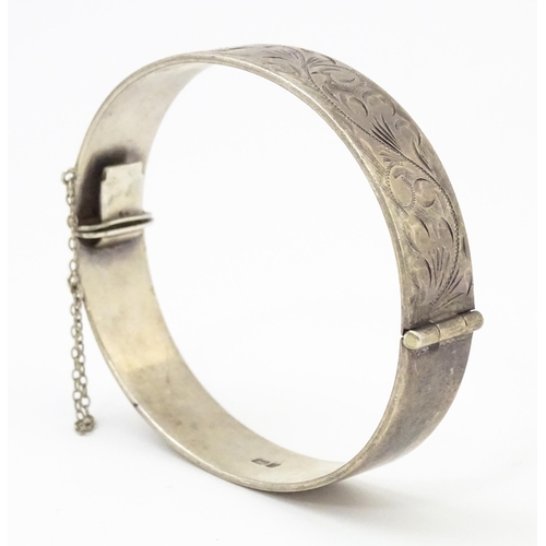 866 - A silver bracelet of bangle form with engraved acanthus scroll decoration hallmarked Birmingham 1976... 