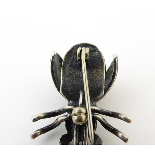 908 - Three assorted brooches / pins to include a silver example formed as a insect / bug set with turquoi... 