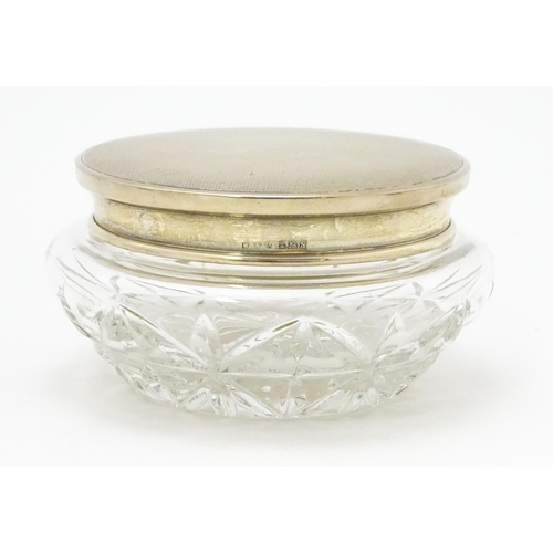 285 - A cut glass dressing table jar / pot, the silver lid with engine turned decoration, hallmarked Birmi... 