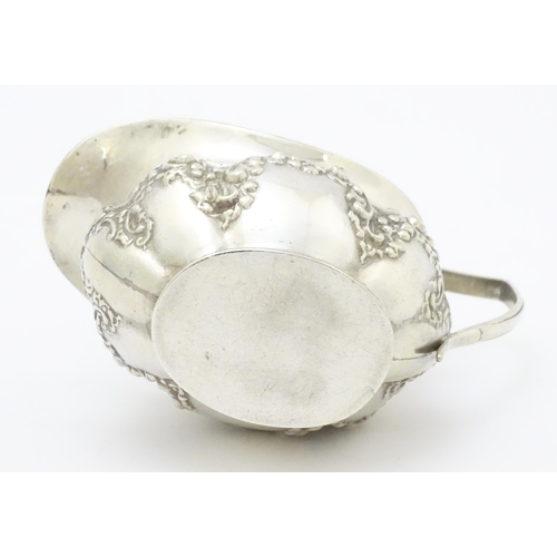 286 - A silver cream jug with embossed floral and foliate decoration hallmarked Birmingham 1903, maker W. ... 