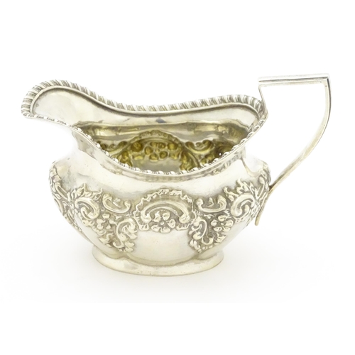 286 - A silver cream jug with embossed floral and foliate decoration hallmarked Birmingham 1903, maker W. ... 