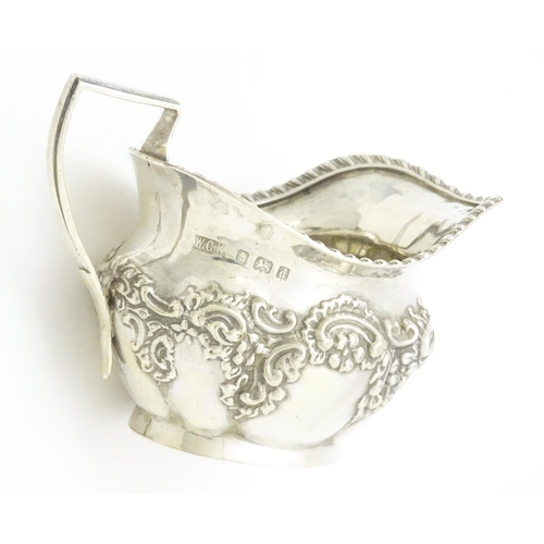 286 - A silver cream jug with embossed floral and foliate decoration hallmarked Birmingham 1903, maker W. ... 