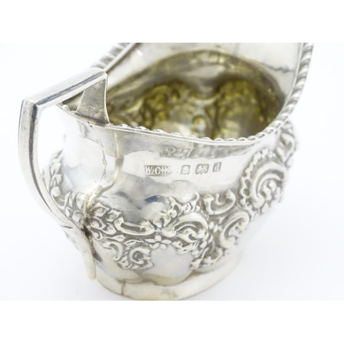 286 - A silver cream jug with embossed floral and foliate decoration hallmarked Birmingham 1903, maker W. ... 