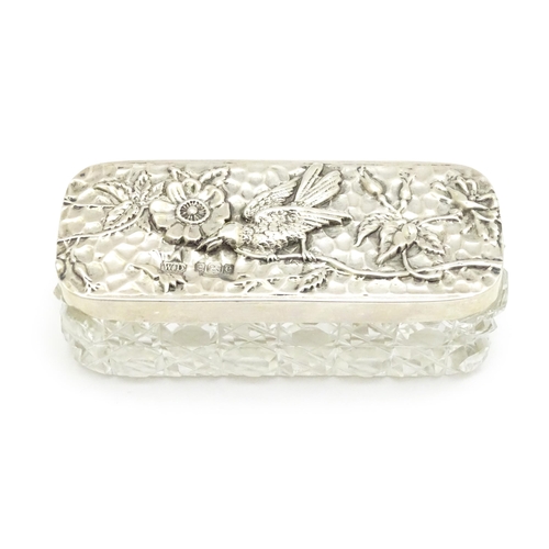 292 - A cut glass dressing table box the silver lid with embossed flower and bird detail, hallmarked Birmi... 